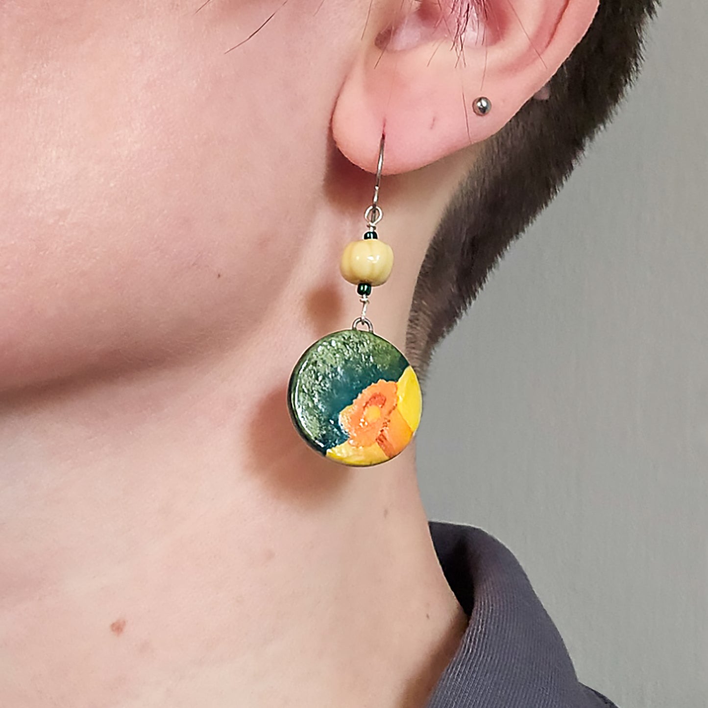 Round Daffodil Dangle Earrings in Yellow and Orange on model.