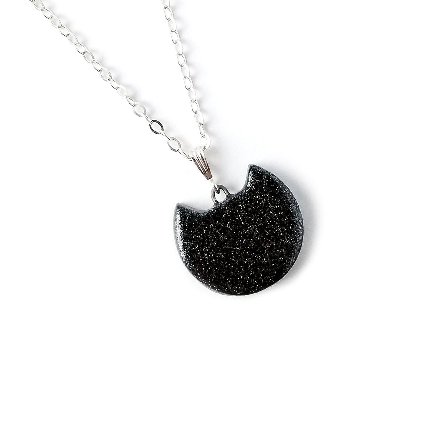 A sparkly black kitten head pendant on a 925 Sterling bail and chain against a white background.